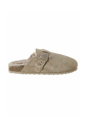Zoccolo beige in camoscio con cinturino regolabile con fibbia, fodera in pelliccia e suola texturizzata per comfort interno ed esterno.