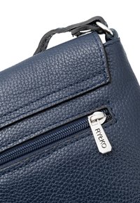 Borsa in pelle blu navy con una superficie texturizzata, zipper argentato con targhetta e attacco della tracolla liscio, che mette in evidenza linee pulite e funzionalità.