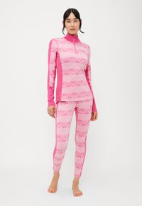 Conjunto térmico justo rosa com mangas longas, colarinho alto e leggings. Apresenta padrões de flocos de neve e riscas em várias tonalidades de rosa.