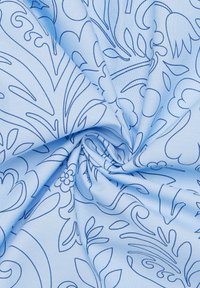 Lichtblauwe stof met een herhalend bloemenpatroon omlijnd in donkerblauw. De textuur lijkt glad en lichtgewicht.