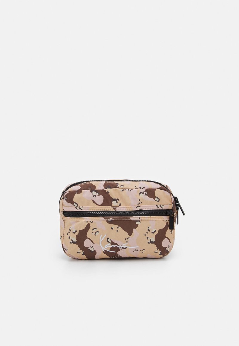 Trousse de maquillage camouflage beige, marron et rose clair. Elle se ferme avec une fermeture éclair et présente un bord noir contrastant, avec une texture de tissu lisse.