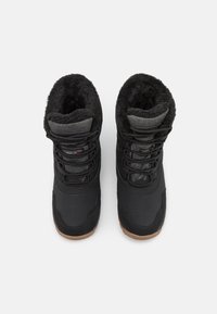 Botas negras aislantes con forro de piel sintética, parte superior de tejido duradero, cordones ajustables y suela de goma texturada en negro. Diseño de punta redonda y plana.