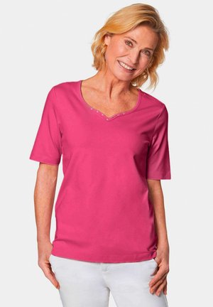Chemise à manches courtes rose vif avec un décolleté en V et des boutons décoratifs le long du col. Texture douce et coupe décontractée.