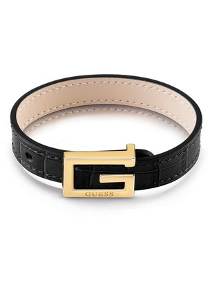Czarna skórzana bransoletka z beżowymi wewnętrznymi przeszyciami, z pozłacaną klamrą w kształcie litery "G" z wygrawerowaną nazwą marki "GUESS".