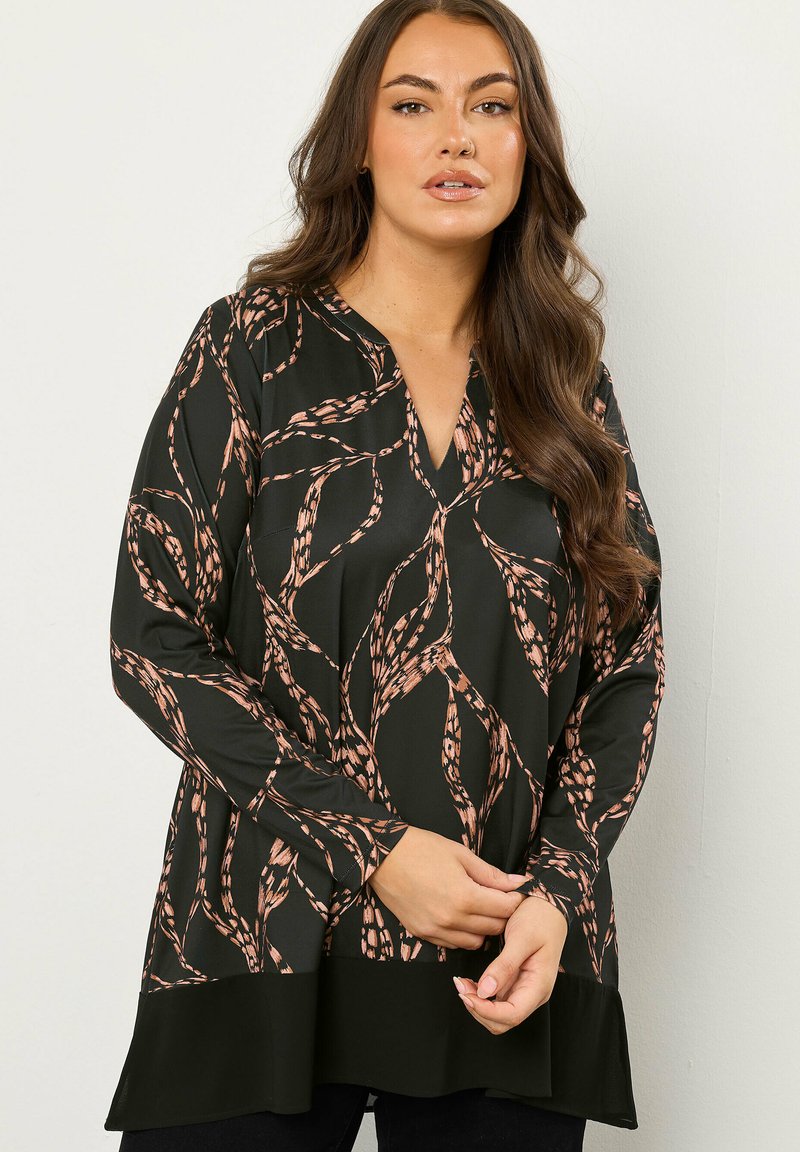Langärmlige schwarze Bluse mit einem rosa und beige abstrakten Muster. Sie hat einen V-Ausschnitt und einen leicht ausgestellten Saum für eine bequeme Passform.