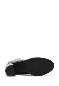 Black leather boot with a smooth upper, rubber sole, and a low heel. Notable for its clean lines and minimalistic design.