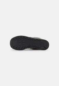 Suela de goma negra con surcos profundos, material superior texturizado gris y bordes reforzados para mayor durabilidad. Patrón de agarre multidireccional.