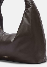 Borsa a mano in pelle marrone con una forma arrotondata unica, caratterizzata da una texture morbida e un sottile logo impresso in oro alla base.