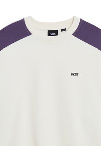 Weißer Pullover mit lila Raglanärmeln, runder Ausschnitt und kleinem schwarzen "VANS"-Logo auf der Brust. Aus glattem Baumwollmaterial.