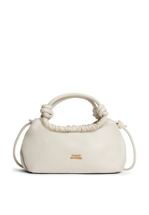 Crèmekleurige zachte leren handtas met een knoophandvat en een klein gouden "Tommy Hilfiger"-logo in het midden aan de voorkant.