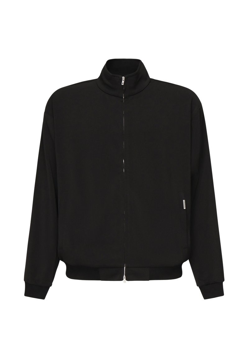 Chaqueta negra con cremallera y alto cuello, mangas largas, bolsillos laterales, y puños y cinturilla elásticos sobre un fondo blanco.