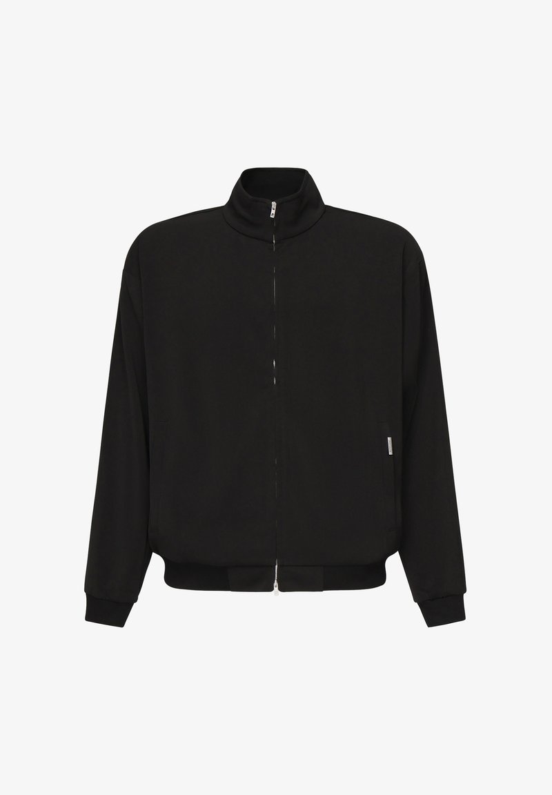 Giacca nera con zip, colletto alto, maniche lunghe, tasche laterali e polsini e vita elastici su uno sfondo bianco.