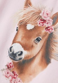 Brun pony med en hvid stripe på næsen, omgivet af pink roser, på en blød pink baggrund. Ponyen har en flydende manke og udtryksfulde øjne.