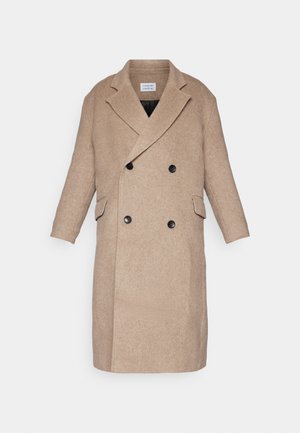 Doppelreihiger Mantel aus hellbeigem Stoff mit zwei vorderen Taschen, schwarzen Knöpfen und einem Reverskragen-Design. Glatte Textur.