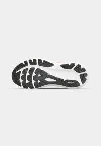 Semelle de chaussure avec un motif de bande de roulement noir et blanc conçu pour l’adhérence et la flexibilité, présenté sur un fond uni gris clair.