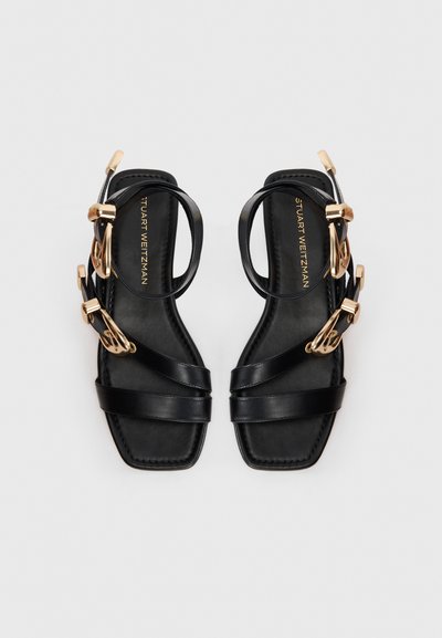 Black leather sandals with multiple crossed straps and a square toe. Gold-tone hardware accents add detail to the adjustable ankle straps.