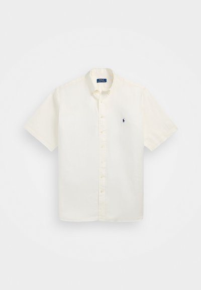 Κοντομάνικο, πουκάμισο με κουμπιά από κρεμ βαμβάκι με μικρό μπλε λογότυπο στο αριστερό στήθος. Ελαφριά υφή και κλασικός σχεδιασμός.