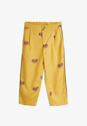 Geltoni džinsai su elastinga juosta, su piešinių atvaizdais, vaizduojančiais animacinius ateivių veidus. Pagaminti iš lengvos medžiagos su tiesia kojų dizainu.
