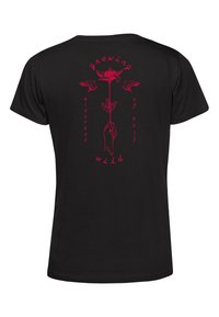 Sort t-shirt med et rødt grafisk print af en hånd, der holder en blomst, accentueret med teksten "growing wild mistress of evil."