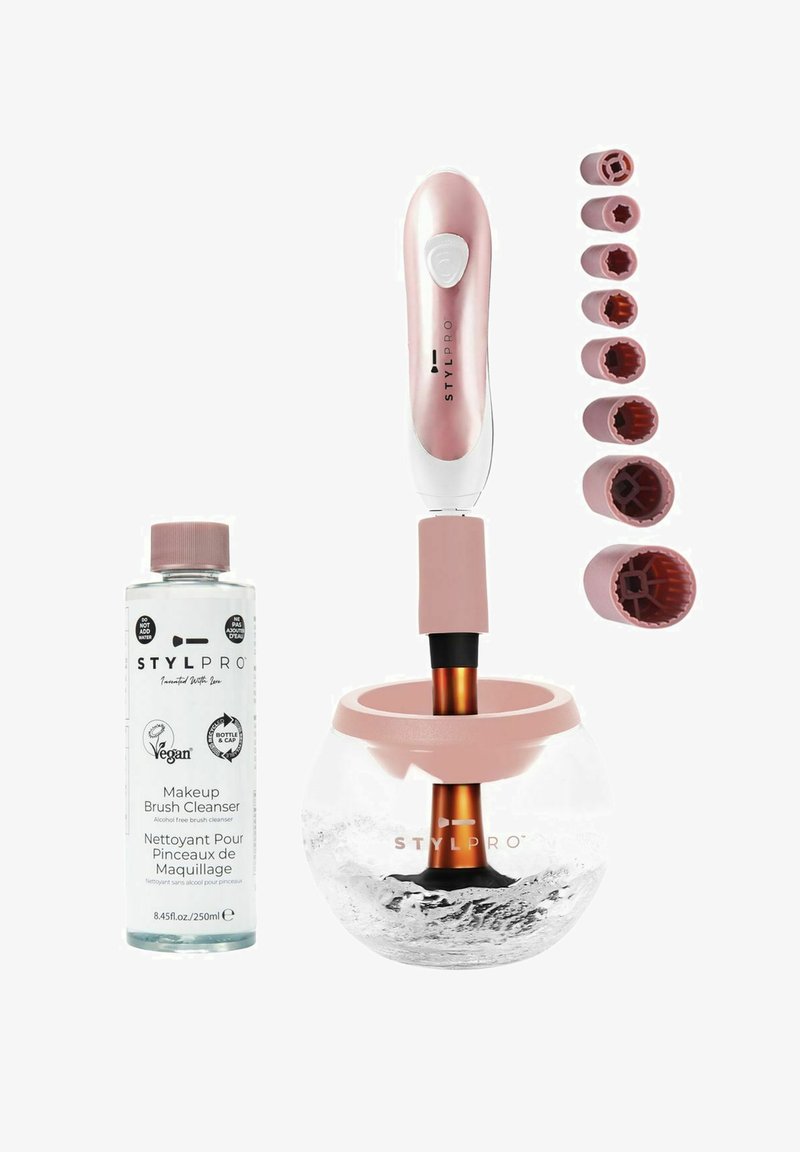 Zestaw do czyszczenia pędzli do makijażu z przezroczystą szklaną miską, różową podstawą i różowym akcentem na elektrycznym czyściku do pędzli. W zestawie znajduje się sześć nasadek do pędzli.