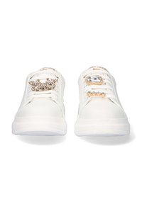 Zapatillas blancas con acentos metálicos, que presentan adornos decorativos en los cordones y una textura suave similar al cuero. Diseño de perfil bajo.