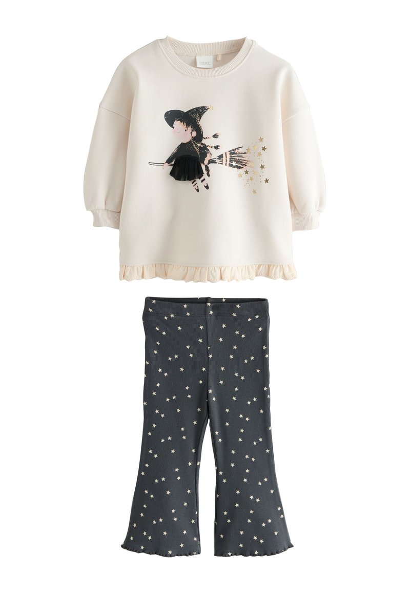 Sweatshirt crème clair avec graphique de sorcière, ourlet festonné ; leggings bleu marine avec motif d'étoiles blanches, texture côtelée, bas évasé.