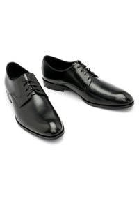 Chaussures habillées noires à lacets avec une finition en cuir lisse, un bout pointu, des détails de couture subtils et des semelles noires fines.