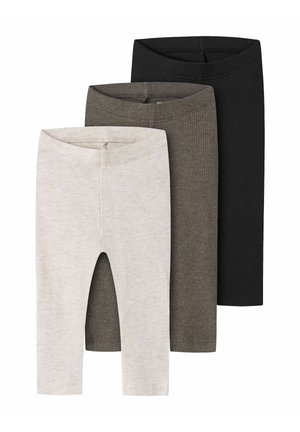 Trois paires de leggings en tissu côtelé beige, vert olive et noir, disposées en chevauchement sur un fond blanc.