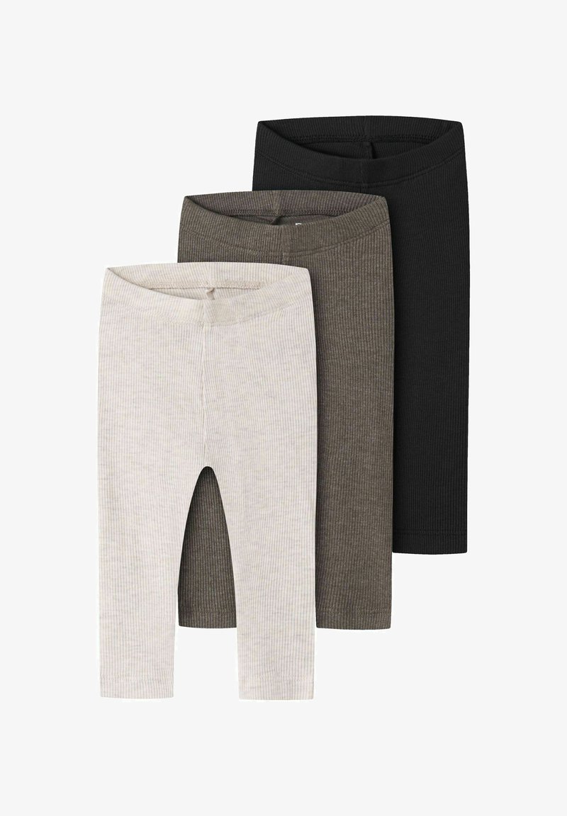 Trois paires de leggings en tissu côtelé beige, vert olive et noir, disposées en chevauchement sur un fond blanc.