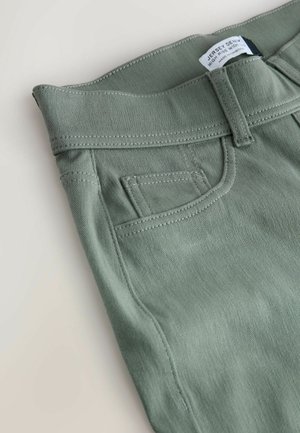 High-rise, wide-leg jeans in muted green denim. Features include a stitched waistband and back pocket, with a label reading "Jersey Denim."