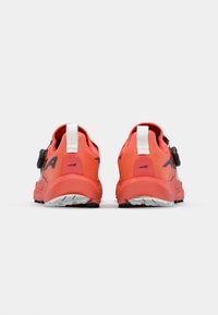 Chaussures de sport en corail vif avec des accents noirs. Elles disposent d'une languette à l'arrière, d'une sangle ajustable et d'une semelle en caoutchouc texturée pour une meilleure adhérence.