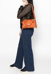 Borsa a mano in pelle arancione con finitura texture, dotata di accessori in argento, doppi manici e una tracolla removibile.