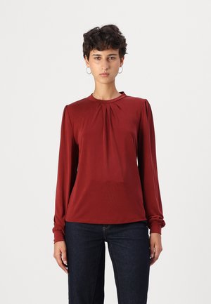 Langermet burgunderbluse med rund hals, som har subtile frontfoldninger og elastiske mansjetter, laget av et glatt, lett stoff.