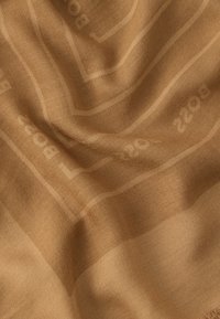 Material țesut bej cu textură netedă, având un model subtil și o strălucire delicată, prezentând numerele "2202" într-o nuanță deschisă.