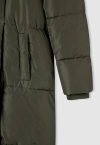 Giacca puffer trapuntata verde con tasca laterale, polsini a costine e texture liscia. Il design presenta dettagli di cucitura orizzontale.