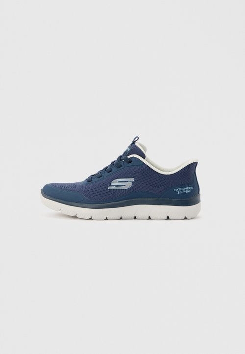 Sneaker Skechers bleu marine à enfiler avec semelle blanche, empeigne en mesh, détail lacets et logo "S" sur le côté.