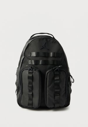 Schwarzer Rucksack mit zwei vorderen Reißverschlusstaschen, Tragegriff oben, gepolsterten Trägern und einem kleinen Jumpman-Logo über den Taschen.