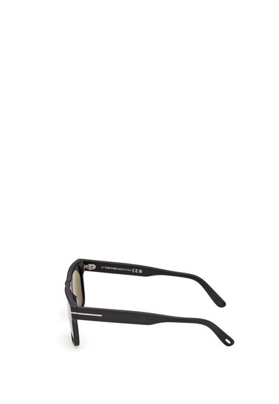 Lunettes de soleil rectangulaires noires Tom Ford avec de fines touches argentées sur les branches, présentées de profil sur un fond blanc.