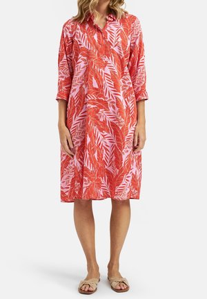 Robe à motifs de feuilles rouges et roses avec un col et des manches trois-quarts, fabriquée en tissu léger, atteignant la longueur du mollet.