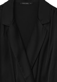 Schwarze Blazer aus weichem, glattem Material, mit Reverskragen und gefältelten Schulterdetails. Das Etikett trägt die Aufschrift "CALLIOPE", Größe S.