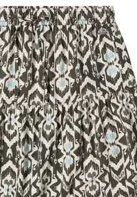 Jupe avec taille élastique et motif géométrique inspiré de l'ikat en noir, blanc et bleu clair, avec cordons à la taille.