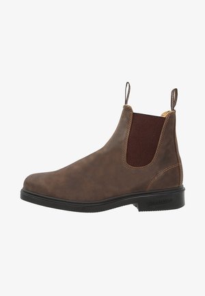 Bota de tornozelo em pele castanha com painéis laterais elásticos, biqueira arredondada e sola em borracha preta. Textura subtil e detalhes de costura.