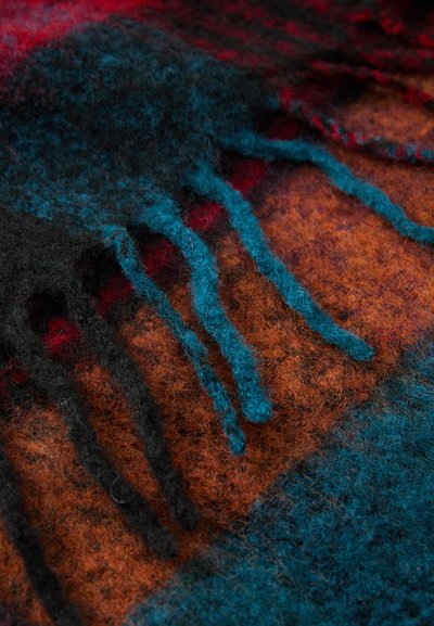 Wool scarf with a multicolored pattern featuring shades of orange, black, and blue. Fringed edges add texture and detail to the design.