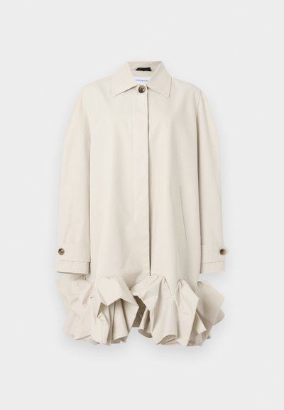 Beige trench coat with a structured design, featuring a ruffled hem, large collar, button closure, and side pocket.