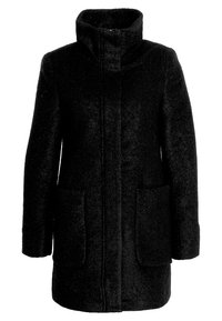 Svart kappa med hög krage, tillverkad av strukturerat material. Har två framfickor och en rak skärning. Inga synliga stängningar.