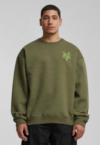 Olijfgroen sweatshirt van stevige katoen, met een ronde hals, ribgebreide manchetten en een groene geborduurde graphic op de linkerborst.