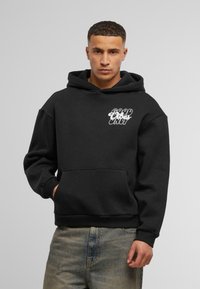 Felpa nera con cappuccio e tasca frontale. Presenta la scritta bianca "GOOD VIBES ONLY" stampata sul petto. Realizzata in morbido tessuto con vestibilità standard.