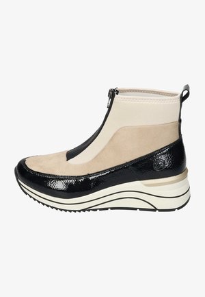 Zapatos altos que combinan ante beige y charol negro. Incluyen cierre de cremallera, suela blanca elevada y detalles texturizados.