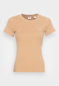 Béžové bavlněné tričko s krátkým rukávem, kulatým výstřihem a malým bílým logem Levi's na hrudi. Hladká textura, přiléhavý střih.