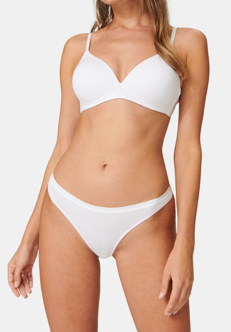 Soutien-gorge blanc avec un design lisse et rembourré, doté de bretelles ajustables, associé à un string taille basse assorti. Les deux sont fabriqués en tissu doux et extensible.